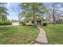 Inviting single-story home with stone facade, manicured lawn, and concrete walkway at 3818 Kessler Boulevard East Dr, Indianapolis, IN 46220