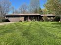 Charming brick home with a well-manicured lawn and a two-car garage on a beautiful day at 3920 Pigeon Creek Ln, Indianapolis, IN 46234