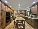 Well-equipped kitchen with stainless steel appliances, custom cabinets, and granite island seating at 5205 Mosswood Ct, Indianapolis, IN 46254