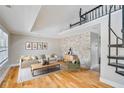 Modern living room with hardwood floors, a stone accent wall, and spiral staircase at 5209 Melrose Ave, Indianapolis, IN 46241