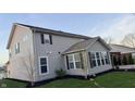Back exterior view of home, showcasing its vinyl siding, well-kept lawn, and serene backyard at 5529 W Turnbuckle Pl, McCordsville, IN 46055