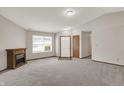 Open living room area featuring neutral carpet, fireplace, and natural light from a large window at 5666 Ensley Ct, Indianapolis, IN 46254