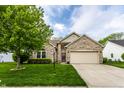 Inviting home with a brick facade, lush green lawn, and attached garage, perfect for Gathering living at 5845 Arrowleaf Ln, Carmel, IN 46033