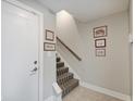 Foyer showcasing a staircase with patterned carpet and framed artwork on the wall at 620 Pomeroy St, Indianapolis, IN 46202