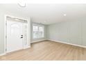 Bright living room with wood floors, decorative wall panels, a large window, and a modern front door at 6507 Tram Ct, Indianapolis, IN 46260