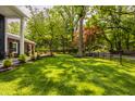 Expansive backyard featuring lush green grass, mature trees, and a classic black fence at 654 E 79Th St, Indianapolis, IN 46240