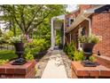Beautiful walkway lined with lush greenery and decorative flower pots leading to the house at 654 E 79Th St, Indianapolis, IN 46240