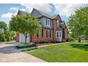Well-maintained home with lush landscaping, a large driveway, and attached garage at 7323 Elm Ridge Dr, Indianapolis, IN 46236