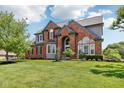 Attractive brick home with manicured lawn, bay window, and covered entryway at 7323 Elm Ridge Dr, Indianapolis, IN 46236