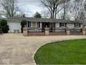 Lovely ranch home with charming brickwork, manicured lawn, and convenient access to an attached two car garage at 7334 E 14Th St, Indianapolis, IN 46219