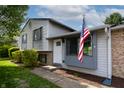 Beautiful home showcasing a cozy entryway with manicured landscaping and American flag at 8232 N Chaucer Ct, Columbus, IN 47201