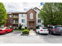 Condo's attractive exterior with brick accents, upper-level balconies, ample parking, and mature trees at 8911 Hunters Creek Dr # 311, Indianapolis, IN 46227