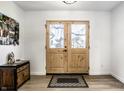 Inviting entryway with wood-framed glass doors, modern flooring, and a stylish console table at 8966 Wooster Ct, Fishers, IN 46038