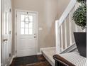Inviting entryway with a white front door, hardwood floors, and a staircase with white railing at 9575 Thradd St, Fishers, IN 46038