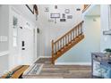 Welcoming foyer with wood floors, a staircase, and decorative wall art at 10417 Mayapple Ct, Noblesville, IN 46060