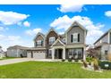 Charming two-story home with brick accents, a three-car garage, and landscaped front yard at 10811 Wild Orchard Ln, Indianapolis, IN 46239