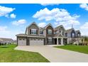 Lovely two-story home with brick and siding, a three-car garage, and a welcoming entrance at 10811 Wild Orchard Ln, Indianapolis, IN 46239