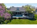 Scenic backyard view highlighting the deck, screened porch, mature trees, and lush landscaping at 10844 Bentwater Ln, Fishers, IN 46037