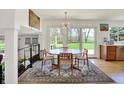 Light-filled dining room with modern chandelier and views of the backyard at 11006 Timber Ln, Carmel, IN 46032