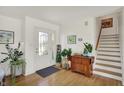 Bright foyer with hardwood floors, white walls, and decorative stairway at 11006 Timber Ln, Carmel, IN 46032