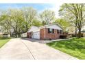 Brick home with a long driveway leading to an attached garage at 11359 Peacock Dr, Indianapolis, IN 46236