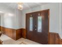 Inviting entryway featuring a dark wood paneled wall and decorative tile flooring at 11415 Central E Dr, Carmel, IN 46032
