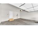 Spacious garage with white door, concrete floor, and access door to the home's interior at 11436 Mossy Ct # 101, Fishers, IN 46037