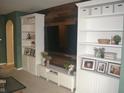 Bright living room with a custom wood feature wall, built-in shelves, and neutral carpet at 12214 Cold Stream Rd, Noblesville, IN 46060