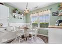 Cozy breakfast nook with a built-in bench, white chairs, a round table, and natural light at 123 Thistlewood Dr, Greenfield, IN 46140