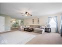 Spacious living room with a plush sectional sofa, ceiling fan and ample natural light at 132 Thistlewood Dr, Greenfield, IN 46140