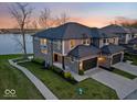 A luxury two-story home with a two car garage, brick accents, professional landscaping, and waterfront views at 13797 E Southshore Dr, Fishers, IN 46037