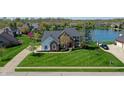 Beautiful brick home featuring a large front lawn, mature landscaping and views of the lake at 14386 Salem E Dr, Carmel, IN 46033