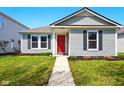Charming single-story home featuring a red front door, well-kept lawn and complementary landscaping at 14429 Banister Dr, Noblesville, IN 46060