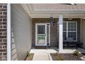 Inviting front porch featuring a seating area, brick accents, and a decorative door, offering a warm welcome at 15142 Blue Ribbon Blvd, Fishers, IN 46040