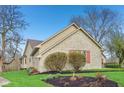 Stone and siding architecture highlights a well landscaped yard with lush greenery at 168 Yorkshire W Blvd, Cumberland, IN 46229