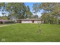 Beautiful exterior view of home, showcasing the lawn, stone facade, and covered side porch at 1710 S Butler Ave, Indianapolis, IN 46203