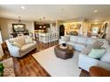 Open-concept living room boasts hardwood floors and neutral decor, seamlessly flowing into the kitchen and dining area at 18756 Brookston Ln, Noblesville, IN 46062