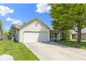 Inviting home with attached garage, concrete driveway, manicured lawn, and charming landscaping at 3114 Village Park N Dr, Carmel, IN 46033