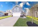 Charming two-story home with a white garage door, gray siding, and a well-manicured lawn at 4046 Denali Dr, Indianapolis, IN 46235