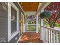 Inviting porch with wood flooring, white railings, and a hanging plant, perfect for relaxing at 4125 Rookwood Ave, Indianapolis, IN 46208