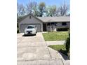 Charming single-story home features a gray brick exterior, well-maintained lawn and a long driveway at 4211 Medina Way, Indianapolis, IN 46227
