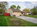 Modest single-story home featuring a one-car garage and a pleasant front lawn at 4411 Rotterdam Dr, Indianapolis, IN 46228
