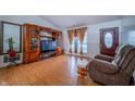Inviting living room featuring hard wood floors, a large TV, and a comfortable chair at 4411 Rotterdam Dr, Indianapolis, IN 46228