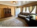 Inviting living room with wood paneling, a patterned rug, and comfortable seating near bright windows at 5817 Oliver Ave, Indianapolis, IN 46241