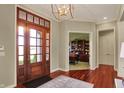 Inviting foyer with hardwood floors, stylish chandelier, and view to office at 6829 Whitetail Woods Ct, Bargersville, IN 46106