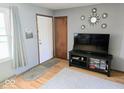 Bright entryway featuring hardwood floors, a white door, and decoratively arranged wall mirrors at 8230 E 11Th St, Indianapolis, IN 46219