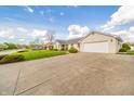 Spacious driveway leading to a well-kept one-story home with an attached garage and manicured front lawn at 838 Deerfield Rd, Anderson, IN 46012