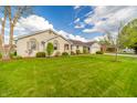 Well-maintained one-story home featuring a lush green lawn and neat landscaping at 838 Deerfield Rd, Anderson, IN 46012