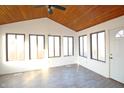 Bright sunroom with vaulted ceiling, wood paneling, large windows and gray vinyl floors at 8911 Country Walk Ct, Indianapolis, IN 46227