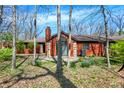 Lovely brick home surrounded by mature trees and landscaping, providing privacy and a natural setting at 9309 Golden Woods Dr, Indianapolis, IN 46268